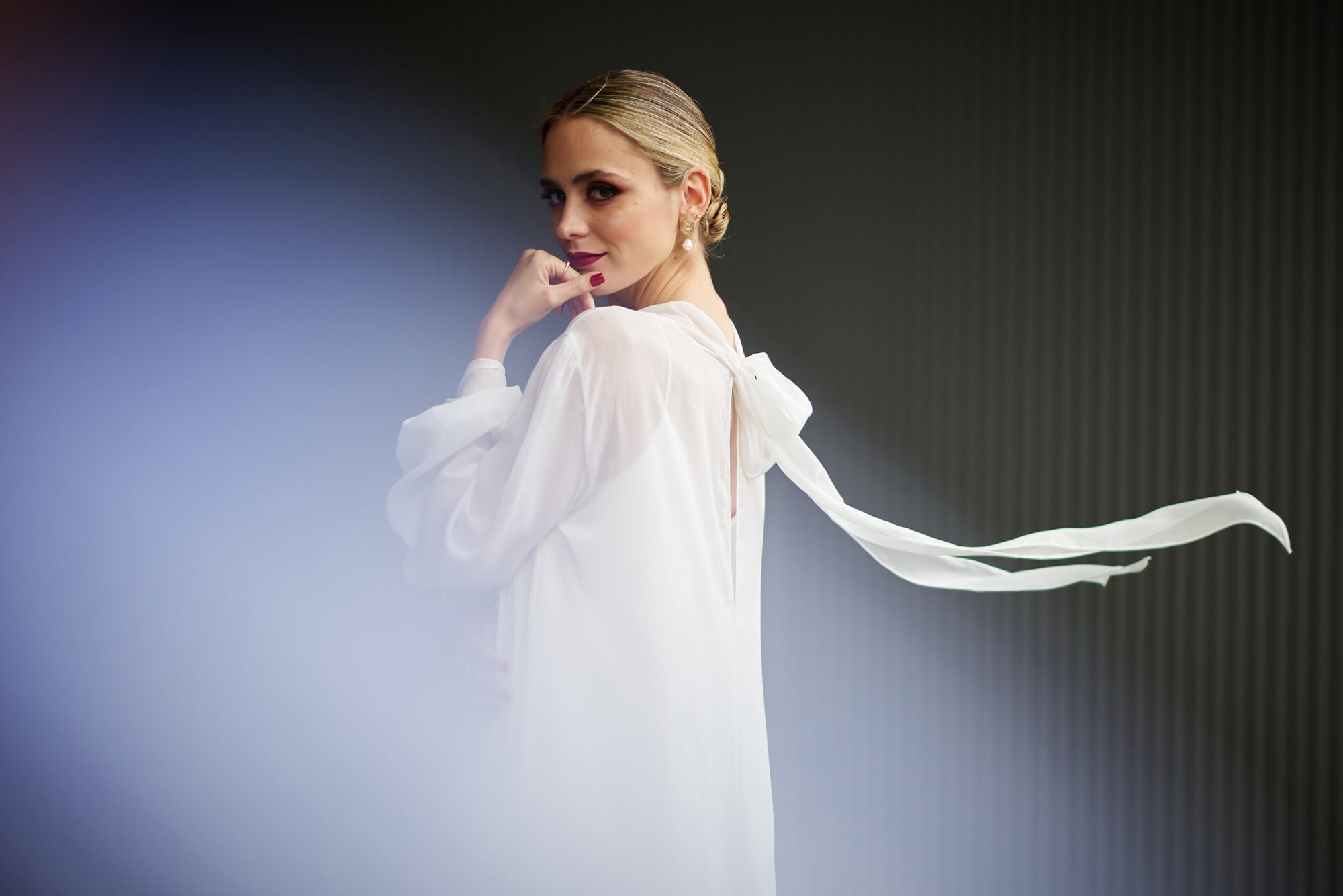 Elegante novia esposa para nosotros en una boda en Bilbao con un vestido, el cual el lazo es mecido por el viento dandole un aspecto super elegante