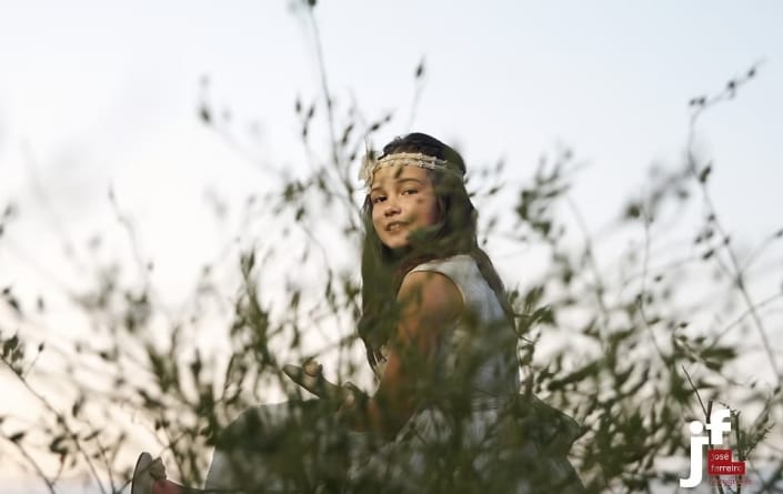 Hola niña, vestida de comunión posa para nosotros, entre las entre las ramas