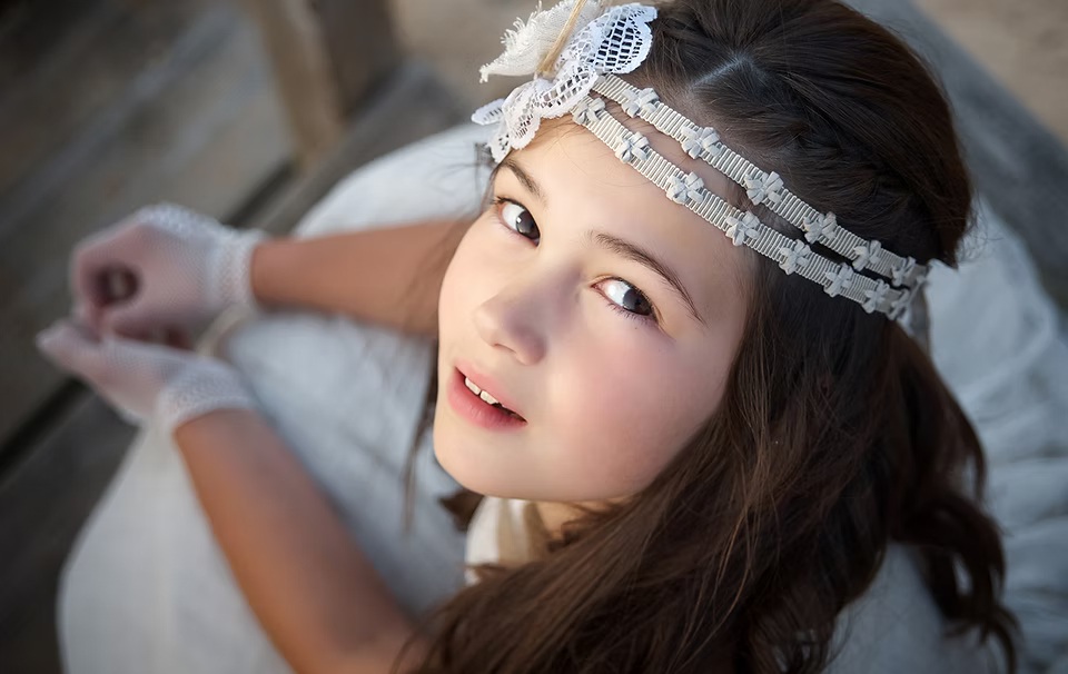 comuniones jose ferreiro 2026-14 Primer plano y retrato de una niña vestida de comunión en la que se toma la foto desde arriba y se ve sus manos y su vestido desenfocado