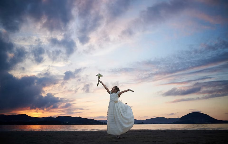 comuniones jose ferreiro 2026-17 Niña de Comunion juega con su ramo en una puesta de sol espectacular en la playa del Regatón de Laredo
