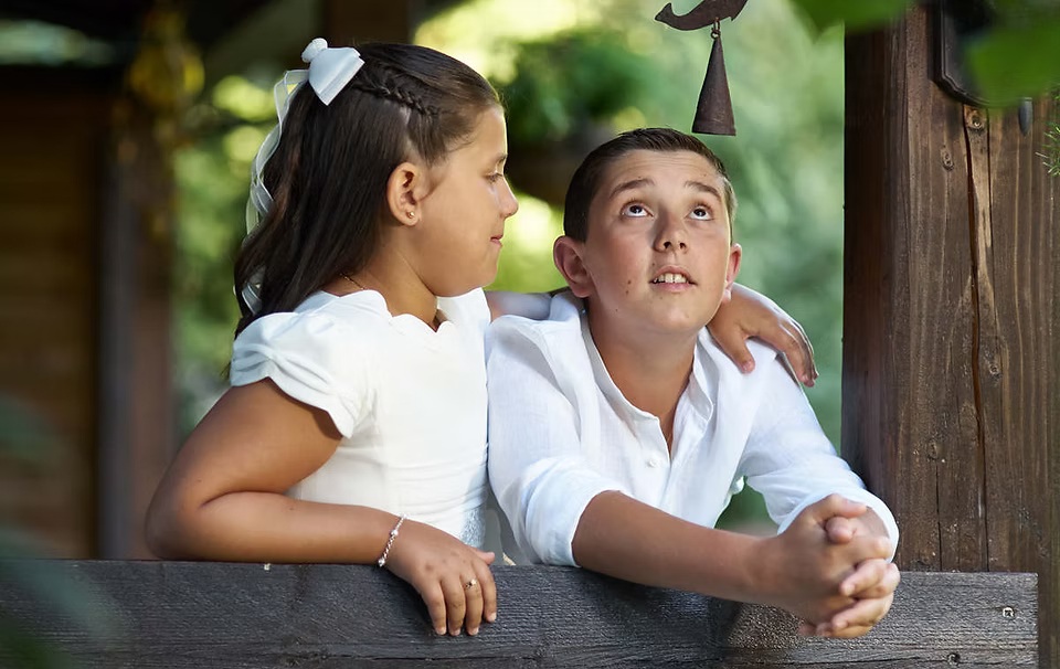 comuniones jose ferreiro 2026-18 Una niña vestida de comunión abraza a su hermano en una foto y en primer plano