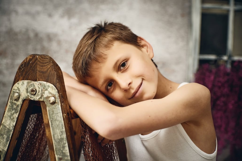 retrato de un niño apollado en una escalera, primwr plano de la cara y brazos