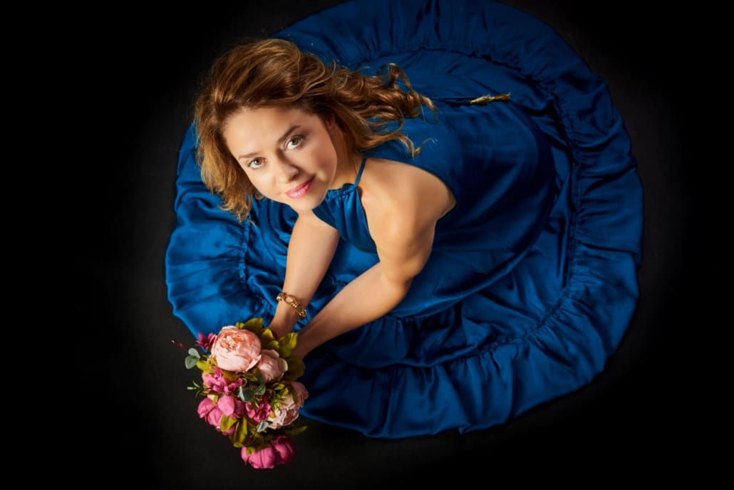 JOSE FERREIRO FOTOGRAFIA - FOTOGRAFIAS DE FAMILIA EN CANTABRIA Y PAIS VASCO foto cenital de una modelo, vestida de azul sostiene un ramo de peonias