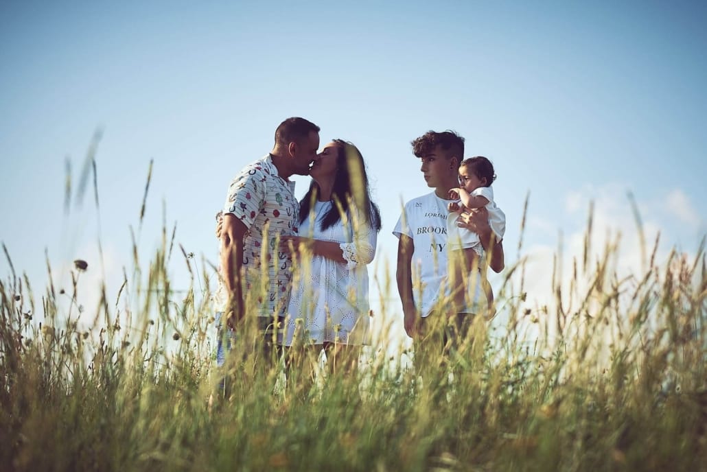 fotografia familiar en el regaton , los papas se besan mientras los hijos miran