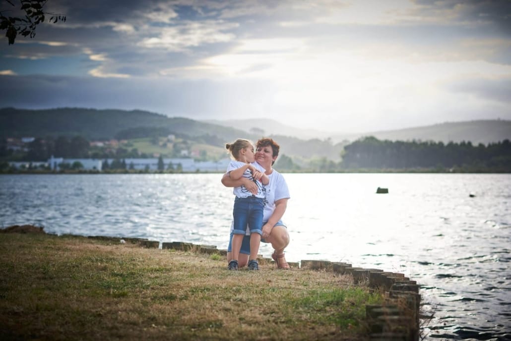foto de familia en el parque, la madre abraza a su pequeño, al fondo, la ria de treto
