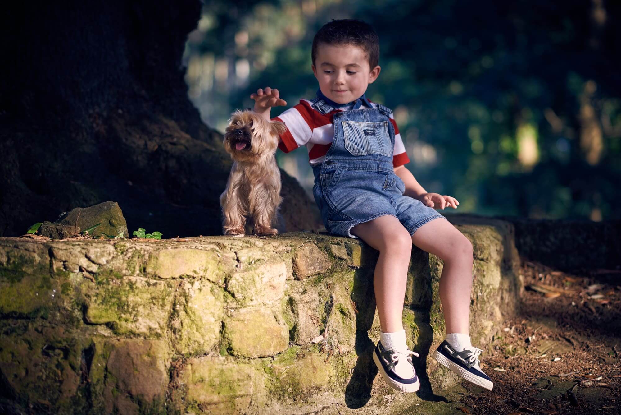 una foto de un niño con su mascota en exteriores