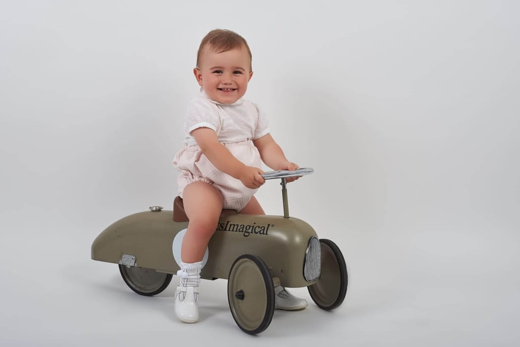 foto infantil, el niño monta un correpasillos que es un coche de carreras vintage